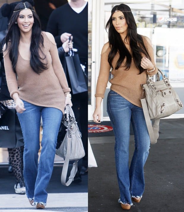 Kim Kardashian sported an asymmetrical sweater from Helmut Lang styled with a pair of on-trend blue flared jeans