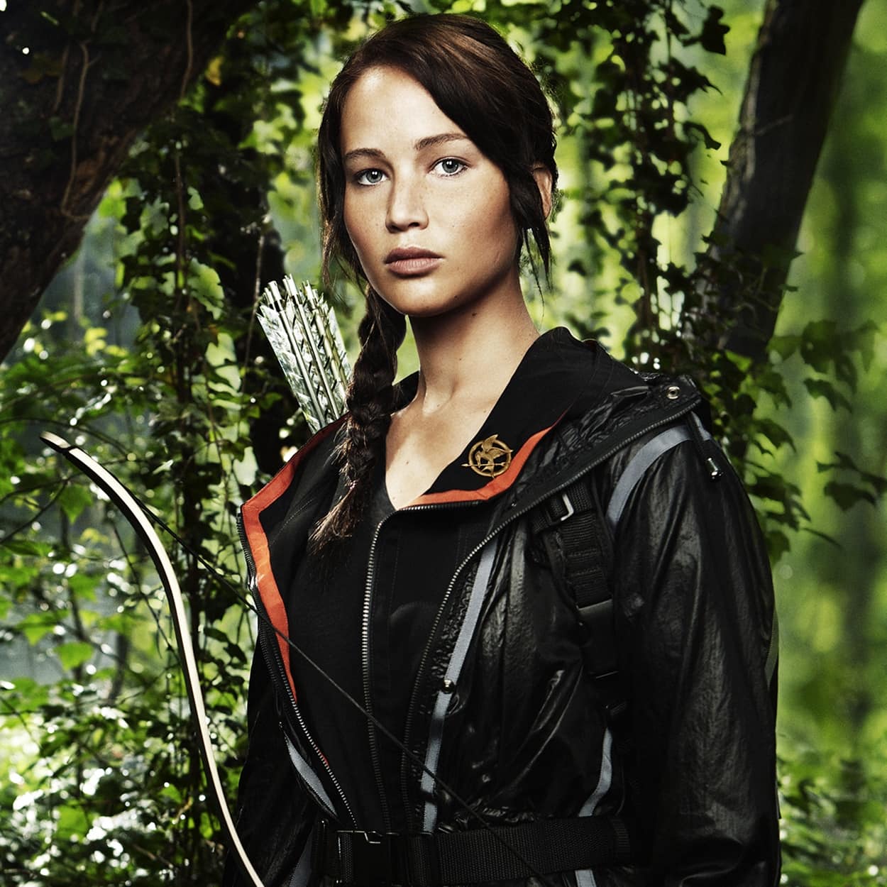 Jennifer Lawrence as Katniss Everdeen wears the Mockingjay pin in the 2012 American dystopian action film The Hunger Games