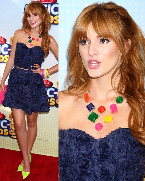 Bella Thorne sported a rosette-detailed cropped top, a matching skirt in navy blue, neon green pumps by Christian Dior, and carried a pink clutch by Glint