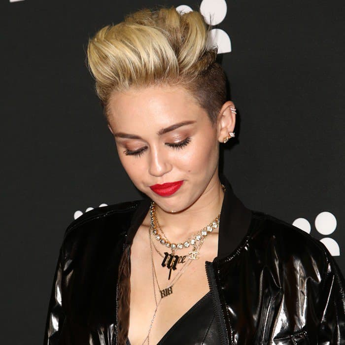 Miley Cyrus wearing an initial pendant necklace