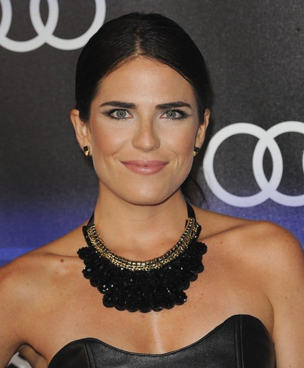 Karla Souza shows off her black-and-gold statement necklace with matching earrings