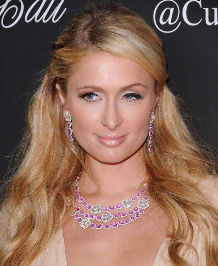 Paris Hilton shows off her sapphire necklace and earring set by Avakian featuring pink sapphires and diamonds in white gold