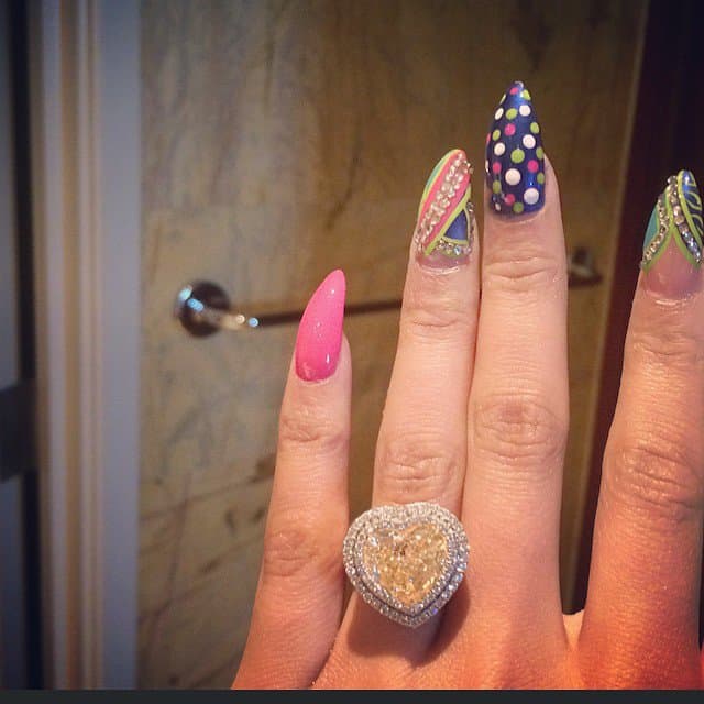 Nicki Minaj shows off a glittering cushion cut diamond ring on her wedding finger given to her by boyfriend Meek Mill