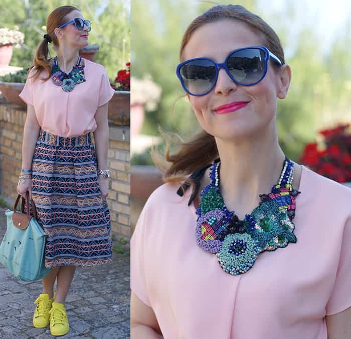 Valentina wears a unique handmade necklace with a plain pink top