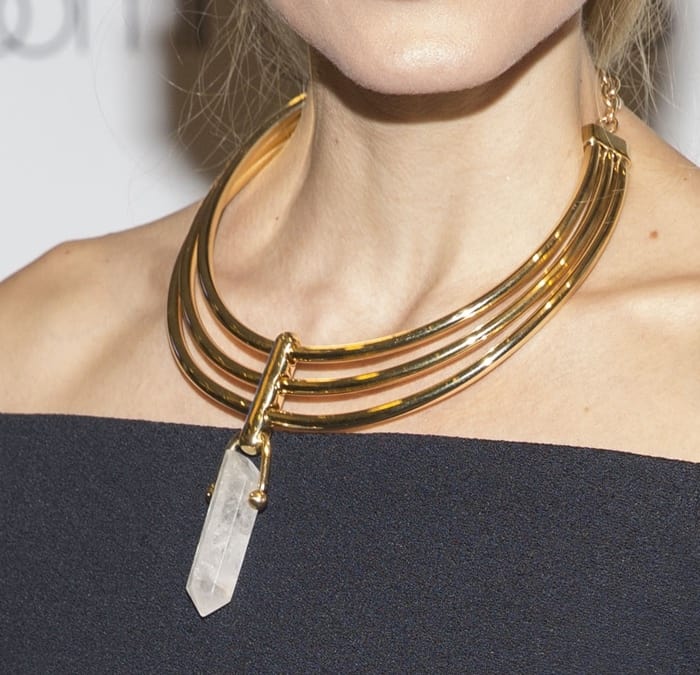 Olivia Palermo wears a statement-making collar BaubleBar 'Occult' necklace featuring a single faceted quartz crystal hanging from a trio of golden bands for a structured but mystical look