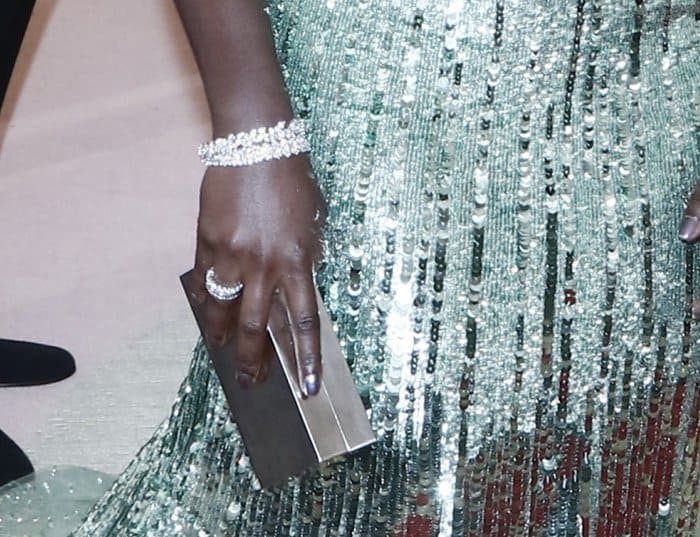 Lupita Nyong'o totes a metallic box clutch and shows off her glittering jewelry